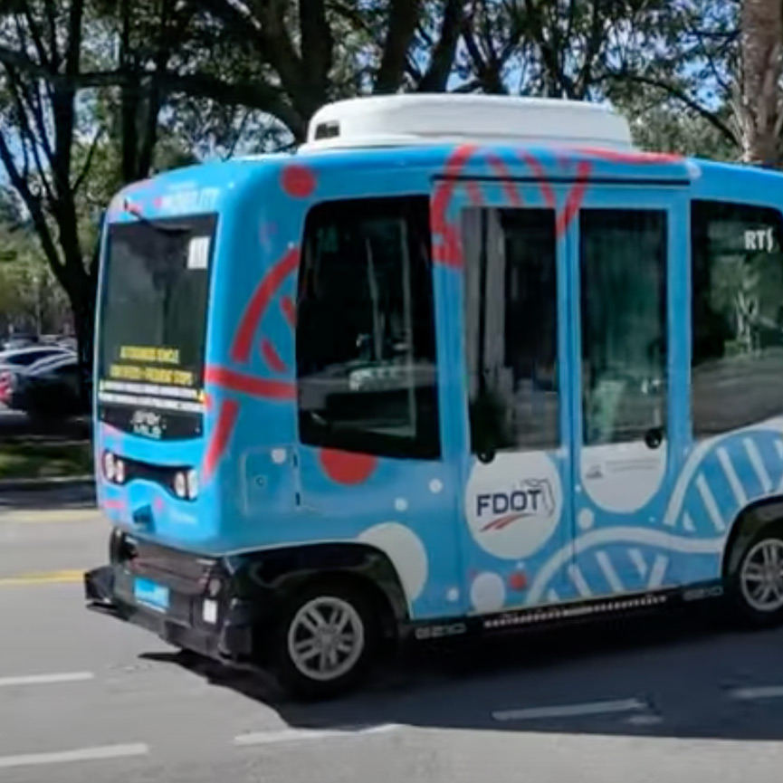 Initiatives-and-Emerging-Technologies Autonomous FDOT shuttle bus driving on a public roadway as part of an emerging transportation technology initiative.