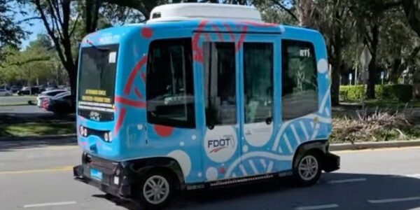 Autonomous FDOT shuttle bus driving on a public roadway as part of an emerging transportation technology initiative.